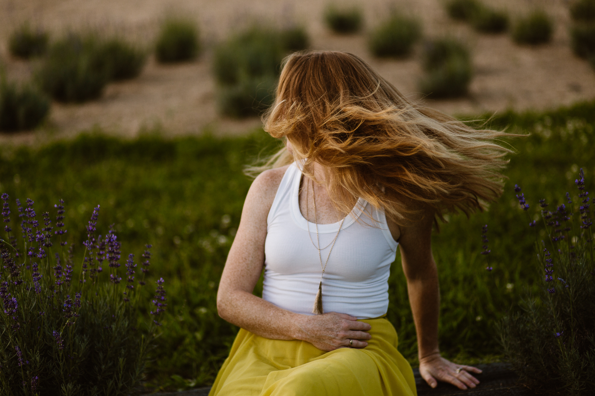 Red headed woman in yellow skirt at sunset in a lavender field.